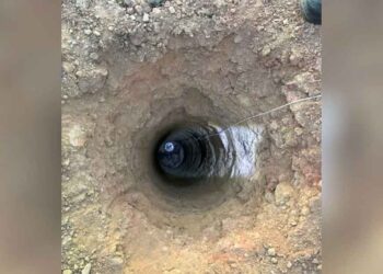 Un homme éclaire un trou profond et trouve deux boules de poils disparues qui ont besoin d'aide